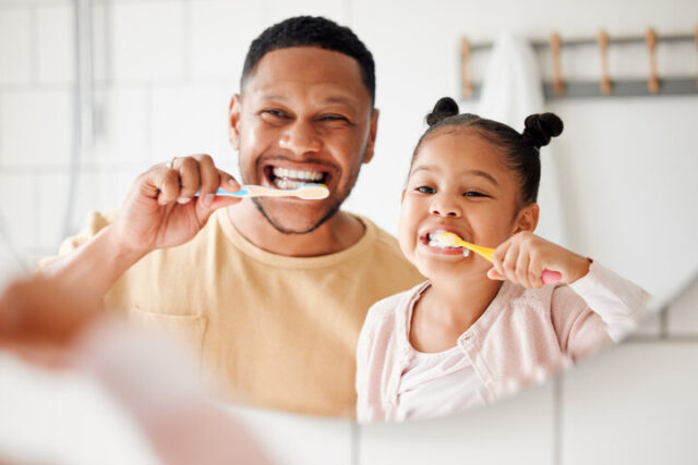 Dad brushing teeth with foster daughter