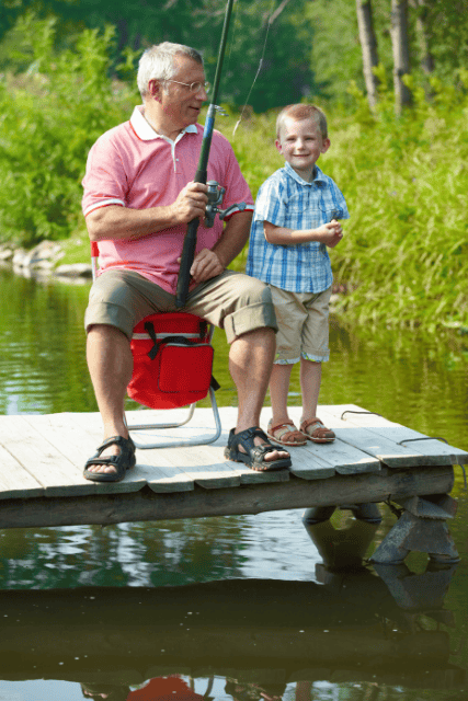 Family fishing together by the water on a sunny day.