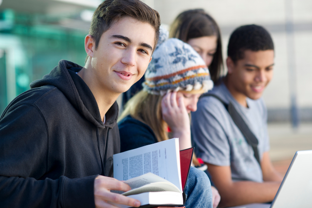 Teen in foster care reading and preparing for academic success with Pathway Caring for Children support.